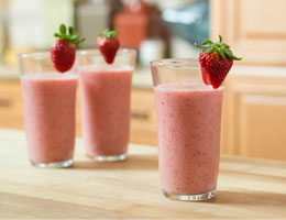 3 full glasses of strawberry shake garnished with strawberries